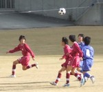空中のボールを競り合う両チームの選手