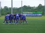 横断幕をバックに円陣を組む選手たち