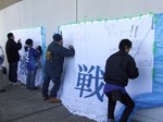 「挑戦」幕にメッセージを書くサポーター