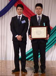新田社長との記念写真に応じる皆勤のサポートスタッフ